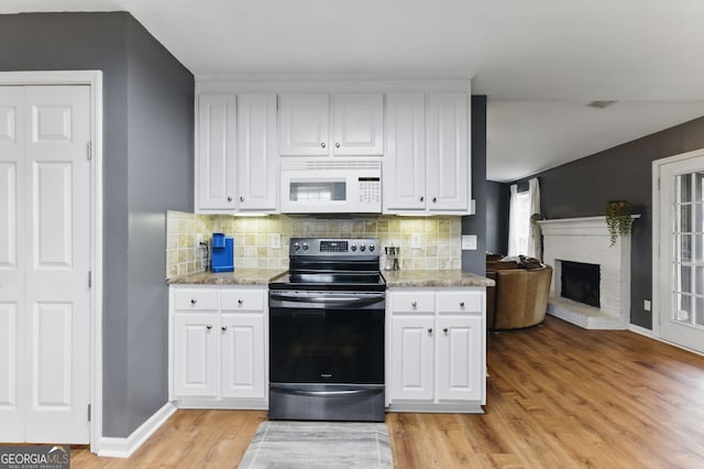 kitchen with light wood finished floors, tasteful backsplash, white cabinets, white microwave, and stainless steel range with electric stovetop