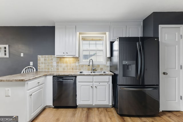 kitchen with dishwasher, black fridge with ice dispenser, a peninsula, white cabinetry, and a sink