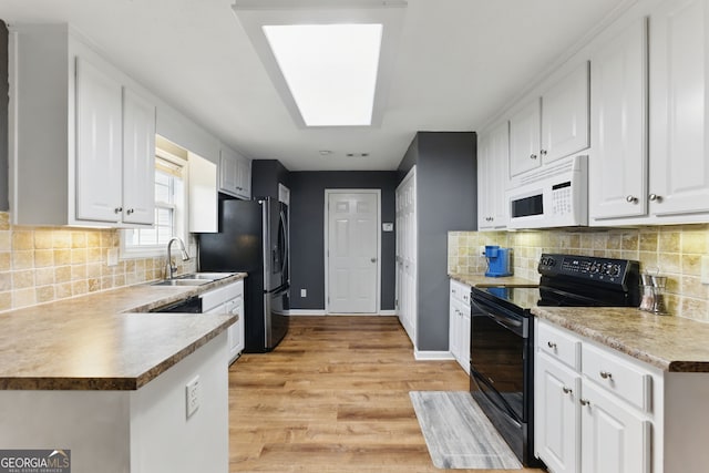 kitchen featuring a sink, baseboards, white cabinets, black appliances, and light wood finished floors