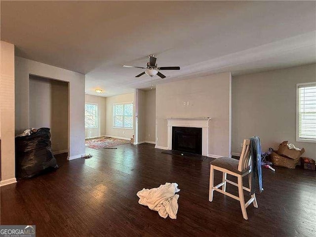 living room with ceiling fan, a fireplace, baseboards, and wood finished floors