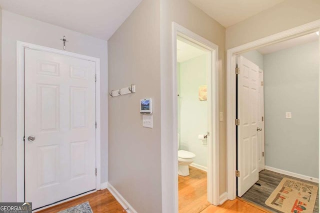 bathroom featuring toilet, baseboards, and wood finished floors