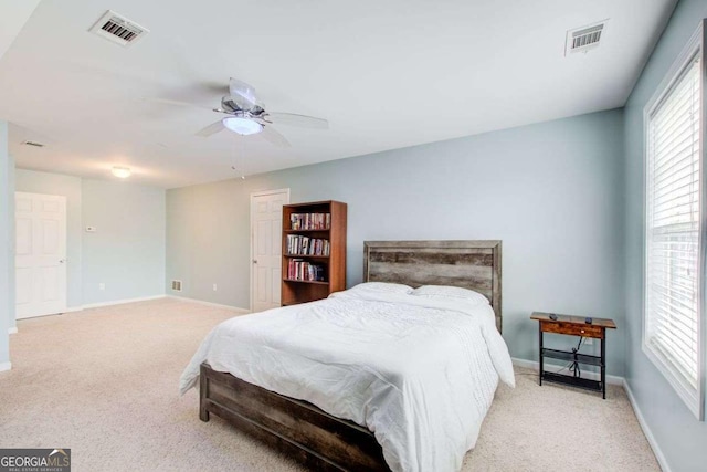 carpeted bedroom with visible vents, baseboards, and ceiling fan