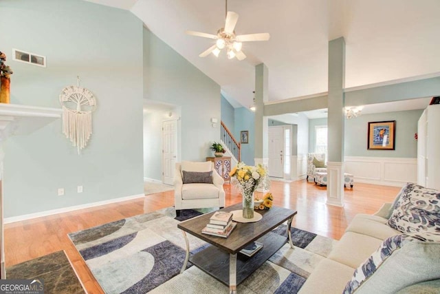 living room with stairs, decorative columns, visible vents, and light wood-type flooring