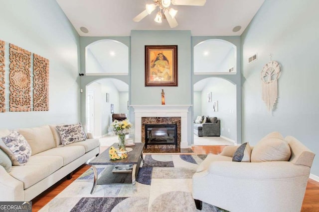 living room featuring visible vents, baseboards, wood finished floors, and a fireplace