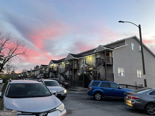 property at dusk featuring uncovered parking and a residential view