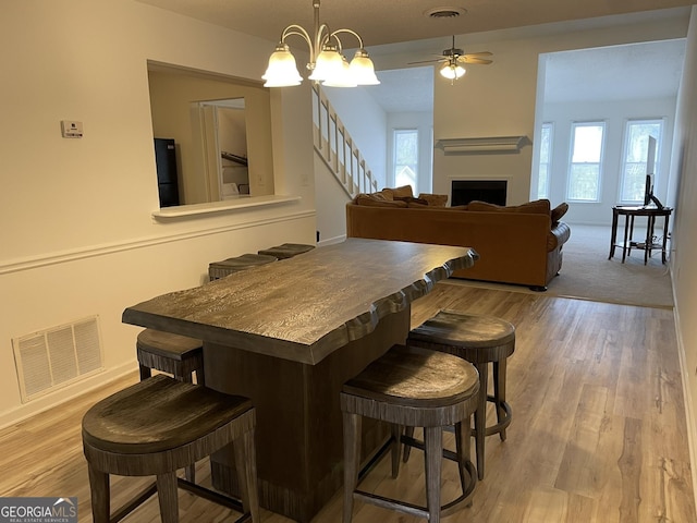 dining area with a fireplace, visible vents, and wood finished floors