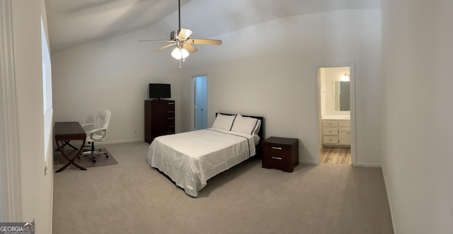 bedroom featuring light carpet, baseboards, lofted ceiling, and ensuite bathroom