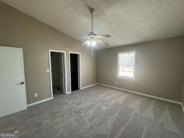 unfurnished bedroom with vaulted ceiling, carpet floors, a spacious closet, and baseboards