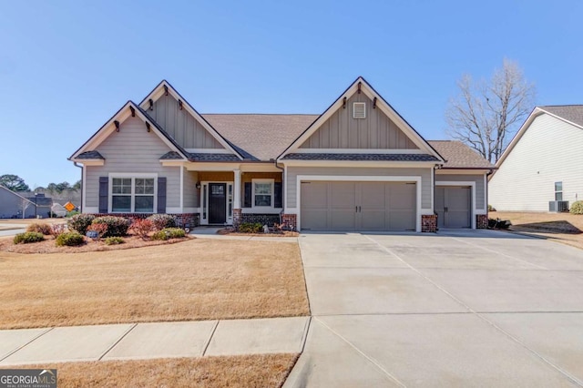 craftsman-style home featuring an attached garage, brick siding, concrete driveway, a front lawn, and board and batten siding