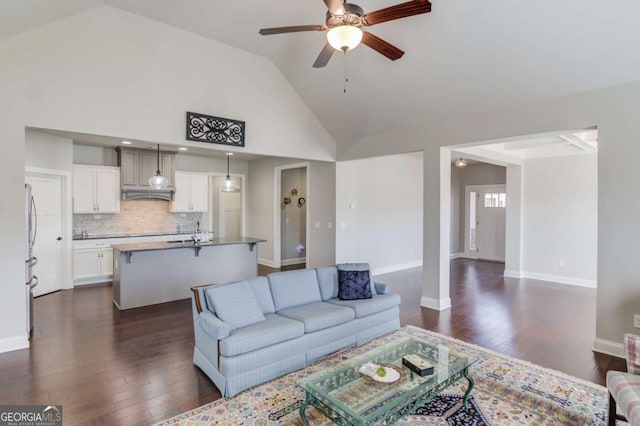 living room with high vaulted ceiling, dark wood-style flooring, baseboards, and a ceiling fan