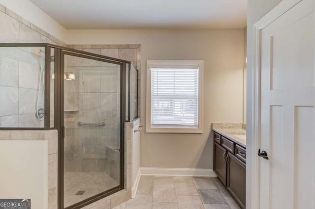 full bathroom with a shower stall, baseboards, and vanity