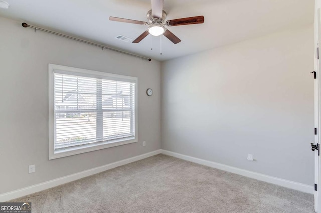 spare room featuring baseboards, visible vents, ceiling fan, and carpet flooring