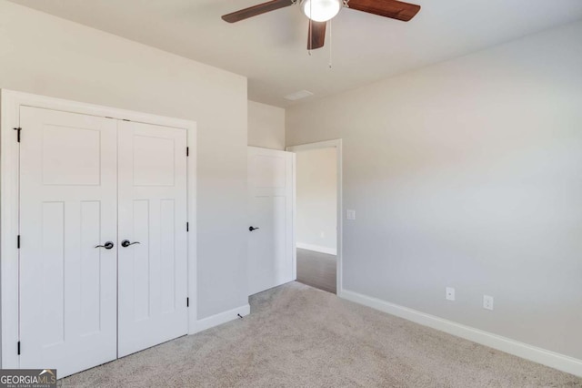 unfurnished bedroom with carpet, a closet, and baseboards