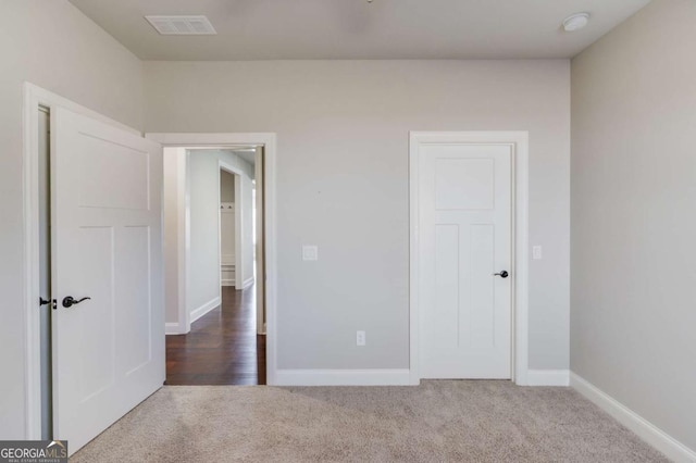 unfurnished bedroom featuring carpet flooring, visible vents, and baseboards