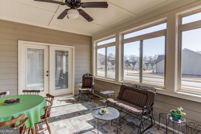 sunroom featuring ceiling fan, plenty of natural light, and a residential view