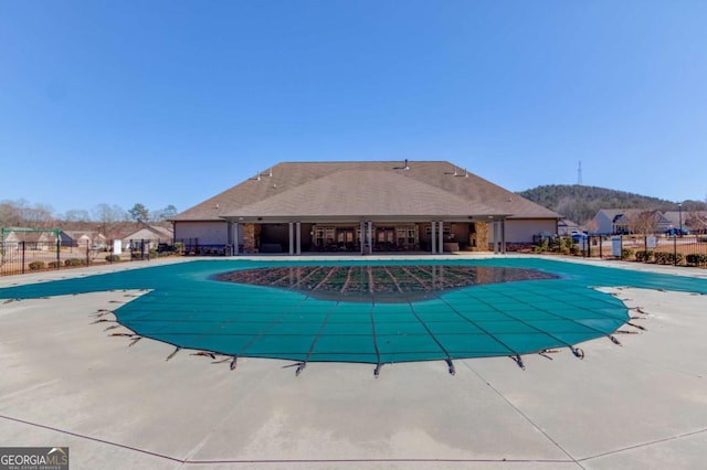 pool with a patio area and fence