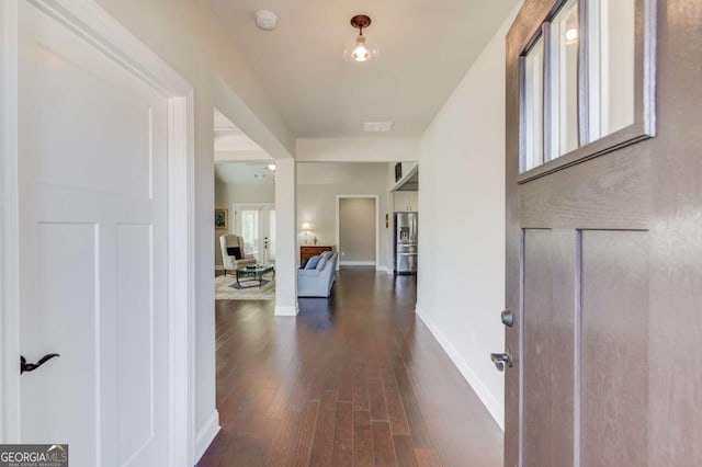 foyer with dark wood-style floors and baseboards