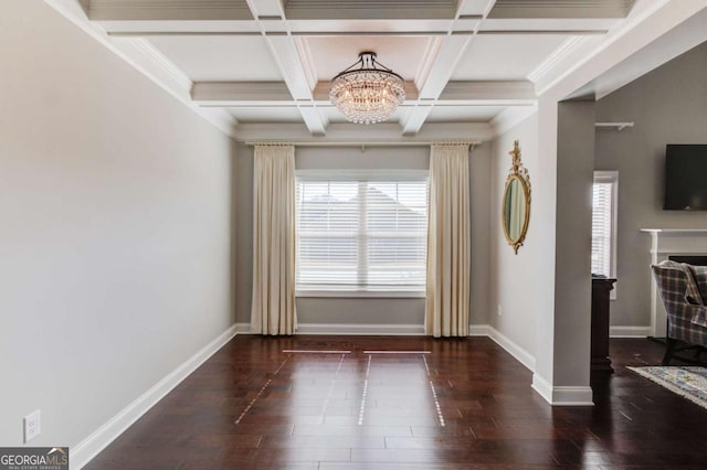 unfurnished dining area featuring baseboards, coffered ceiling, wood finished floors, and an inviting chandelier