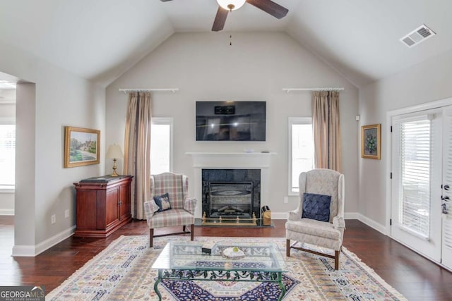 sitting room with visible vents, vaulted ceiling, a wealth of natural light, and wood finished floors