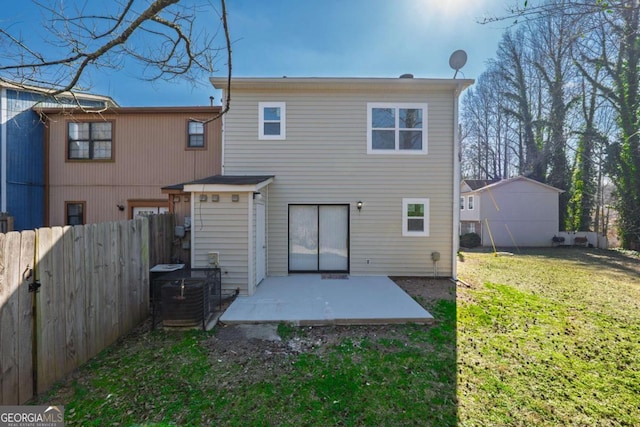 rear view of property with a patio area, fence, central AC, and a yard