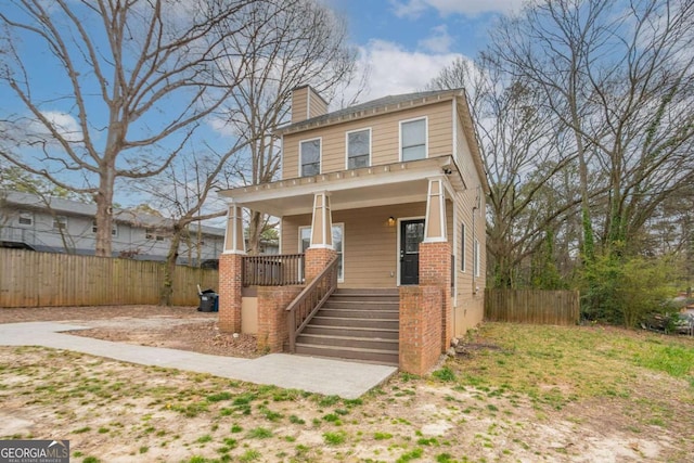 traditional style home with a porch, fence, a chimney, and stairs