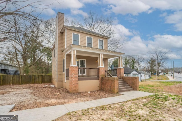 traditional style home with covered porch, stairs, a chimney, and fence