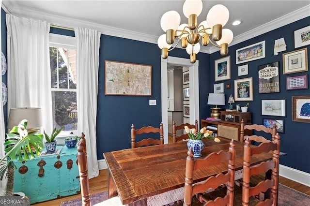 dining room featuring ornamental molding, wood finished floors, baseboards, and an inviting chandelier