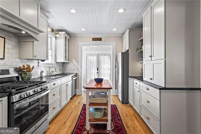 kitchen with dark countertops, stainless steel appliances, french doors, open shelves, and a sink