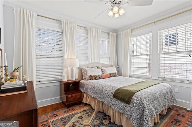 bedroom featuring ornamental molding, ceiling fan, baseboards, and wood finished floors