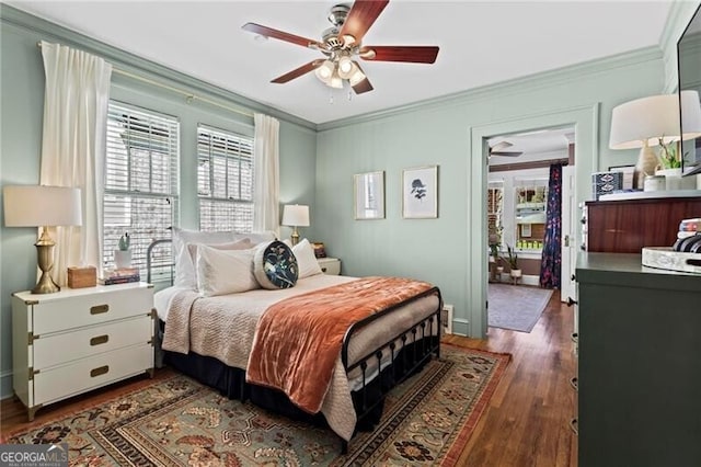 bedroom with dark wood-style floors, crown molding, and ceiling fan