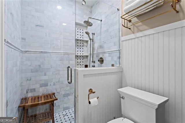 full bath featuring a shower stall and toilet