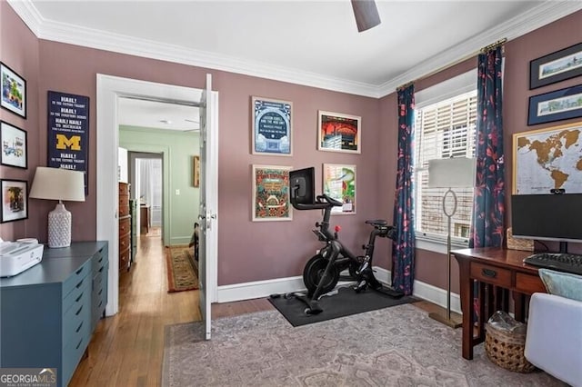 workout area featuring a ceiling fan, baseboards, ornamental molding, and wood finished floors