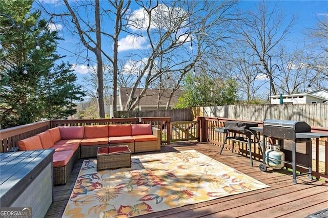 wooden terrace featuring a fenced backyard, an outdoor living space, and area for grilling