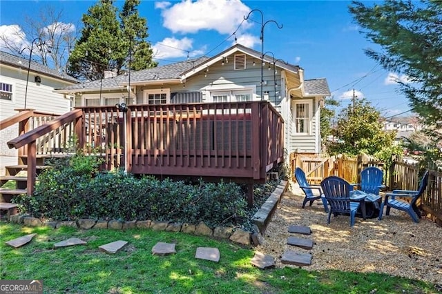 rear view of property with a deck and fence