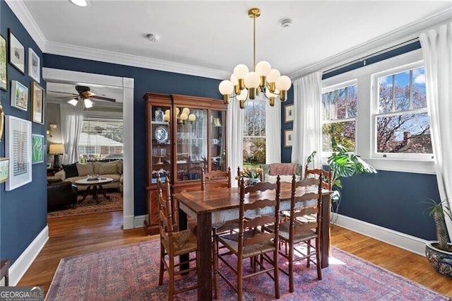 dining room with baseboards, ornamental molding, a chandelier, and wood finished floors