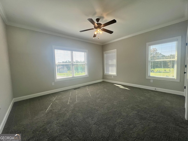 spare room featuring dark carpet, visible vents, crown molding, and baseboards