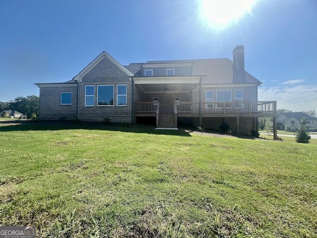 view of front of home with a front lawn, a wooden deck, and brick siding