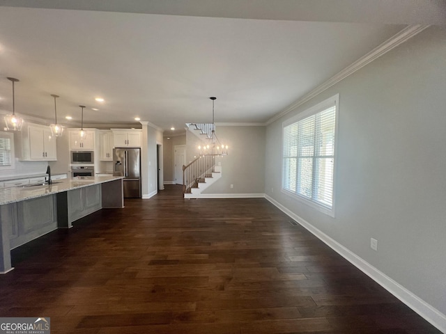 interior space with appliances with stainless steel finishes, crown molding, dark wood finished floors, and a sink