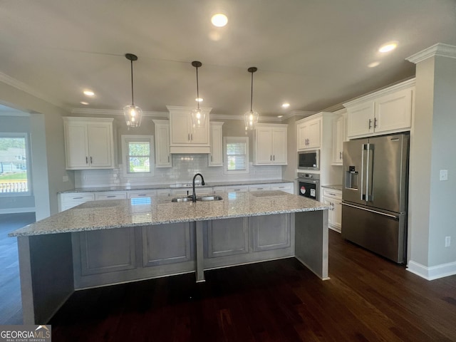 kitchen featuring white cabinets, dark wood finished floors, a spacious island, stainless steel appliances, and a sink