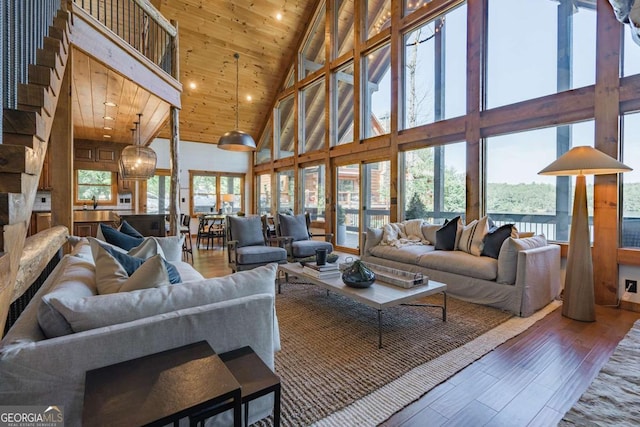 living room featuring a towering ceiling, wood ceiling, and wood finished floors