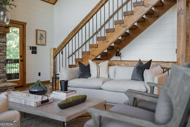 living area featuring stairs and wooden walls