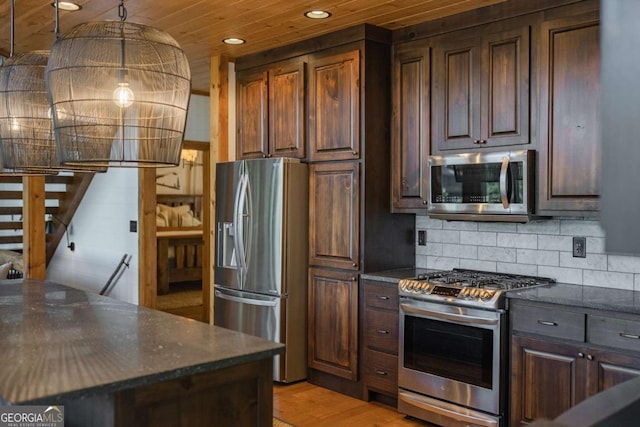 kitchen with light wood finished floors, decorative backsplash, appliances with stainless steel finishes, dark brown cabinetry, and wooden ceiling