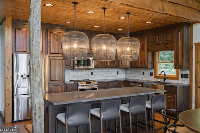 kitchen featuring wood ceiling, appliances with stainless steel finishes, a breakfast bar, and backsplash