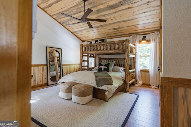 bedroom featuring a wainscoted wall, wood ceiling, hardwood / wood-style flooring, vaulted ceiling, and wood walls