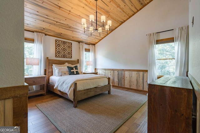 bedroom with wood ceiling, wainscoting, vaulted ceiling, and multiple windows