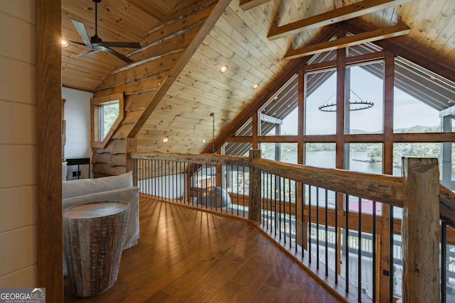 additional living space with vaulted ceiling with beams, a water view, a ceiling fan, wooden ceiling, and hardwood / wood-style flooring