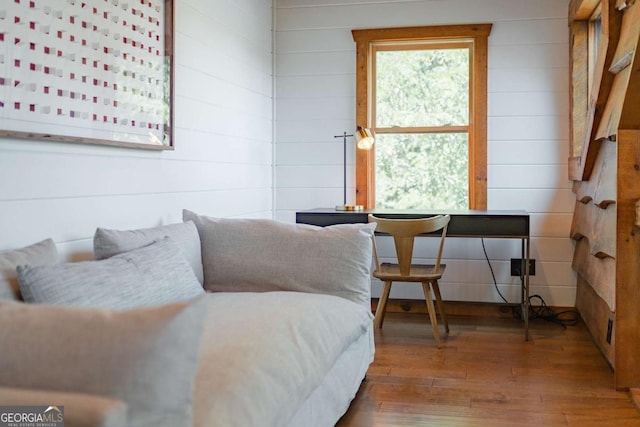 living area with wood walls and wood-type flooring