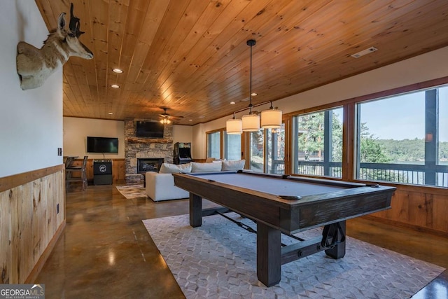 game room featuring wooden ceiling, a wainscoted wall, concrete flooring, a fireplace, and recessed lighting