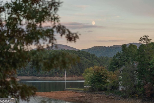 property view of mountains featuring a water view and a forest view