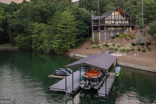 view of dock with boat lift, a water view, and a wooded view